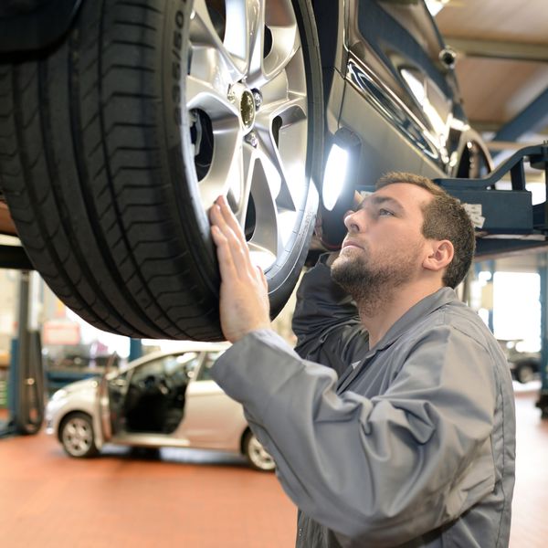 A mechanic in a workshop checks and inspects a vehicle for defects. Kansas City car defects attorney.