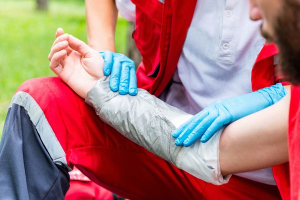 Medical worker treating burns on man's hand. First aid training. Call our Kansas City burn injury attorney today.